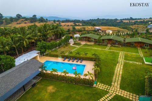 een luchtzicht op een resort met een zwembad bij EKOSTAY Luxe - Woodstock Villa I 2 Acre Property I Cricket Turf I Party Friendly in Karjat