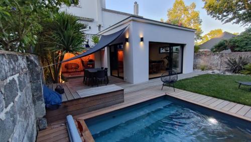 une cour arrière avec une piscine et une maison dans l'établissement Maison nantaise avec piscine proche du centre ville, à Nantes