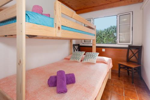 a bedroom with a bunk bed with purple towels on it at Apartamento en complejo de zonas ajardinadas-c11 in Ciutadella