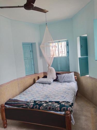 - une chambre avec un lit et un ventilateur de plafond dans l'établissement Shanthi House, à Mysore