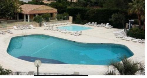 ein großer Pool mit Liegestühlen und sidx sidx sidx in der Unterkunft Loucasa in Roquebrune-sur-Argens