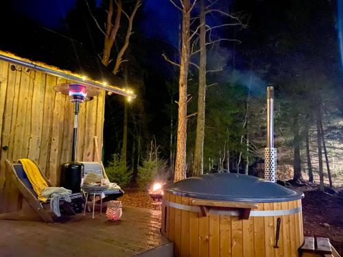 a hot tub sitting next to a wooden cabin at night at Paadikuur Spitham in Põõsaspea