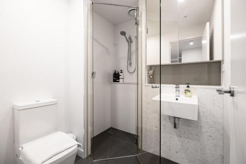 y baño con ducha, aseo y lavamanos. en Panoramic Views 2br With Pool And Free Carpark, en Melbourne