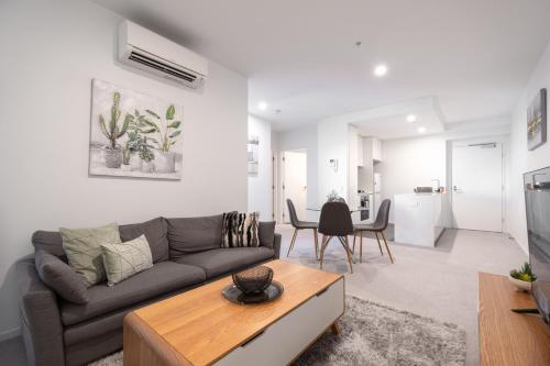 a living room with a couch and a table at Panoramic Views 2BR with Pool and Free carpark in Melbourne