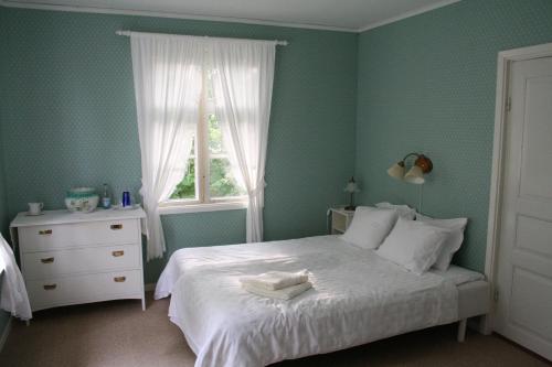 a bedroom with a white bed and a window at Greby Bed & Breakfast in Räpplinge