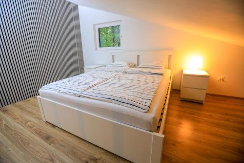 1 dormitorio con cama blanca y mesita de noche en Bizon Village en Zalesie Górne