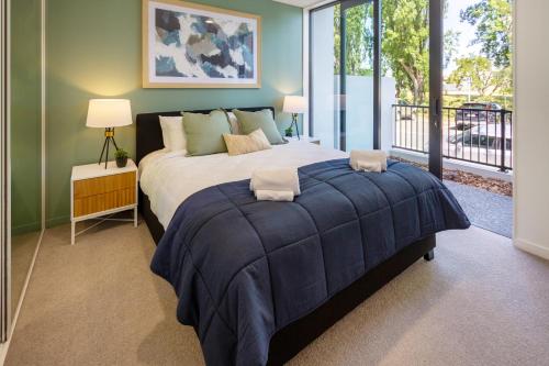 a bedroom with a large bed and a balcony at Unbeatable Central City Location 2 bed Single lvl in Christchurch