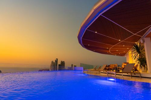 a swimming pool on top of a building with the ocean at Akara Hotel Pattaya in Pattaya North