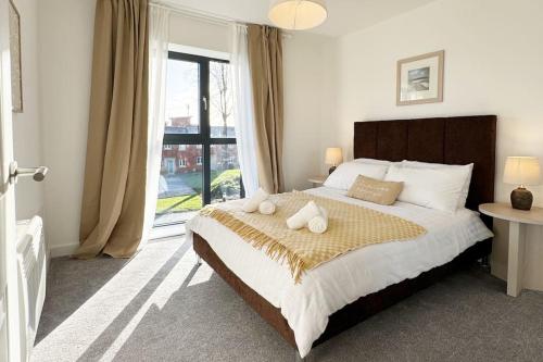a bedroom with a large bed with a large window at Newly built apt in central Derby with on street parking in Derby