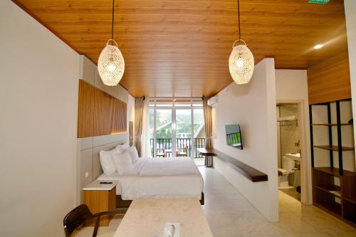 a bedroom with a bed and a window and lights at Gulala Azana Hotel & Resort Guci Tegal in Tegal
