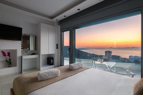 a bedroom with a large bed and a large window at RhodesRentalsgr presents Rhodes Skyline Suites in Ixia