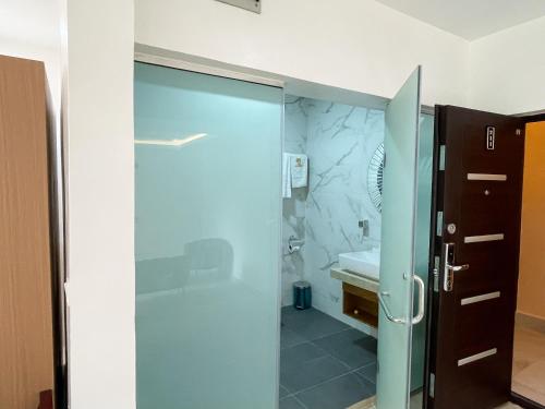 a bathroom with a glass shower and a sink at Address hotel and towers Abuja in Abuja