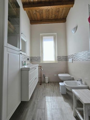 a white bathroom with a sink and a toilet at Oasi di pace nella Val di Taro in Compiano