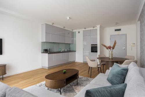 sala de estar con sofá y mesa en Wilanów Branickiego Deluxe Apartment, en Varsovia