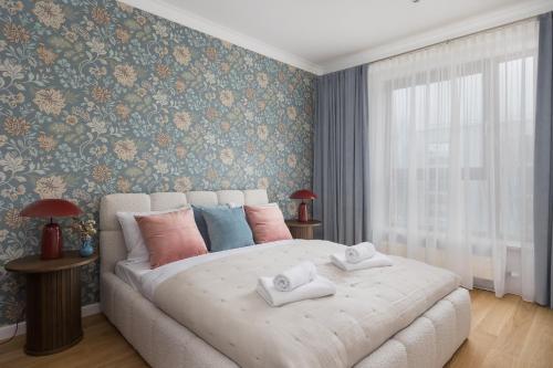 a bedroom with a large bed with pillows on it at Wilanów Branickiego Deluxe Apartment in Warsaw