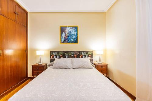 - une chambre avec un grand lit et 2 tables de chevet dans l'établissement Terraza Playa y calle peatonal ESS03377, à Saint-Sébastien