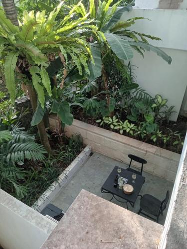 a patio with a table and chairs and plants at Martini Suite and Villa in Kerobokan