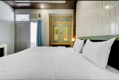ein großes weißes Bett in einem Zimmer mit Fenster in der Unterkunft Hi hotel By Madras in Rishikesh