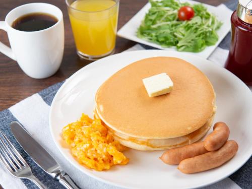 a plate of pancakes and scrambled eggs with a piece of butter at APA Hotel Ueno Hirokoji in Tokyo