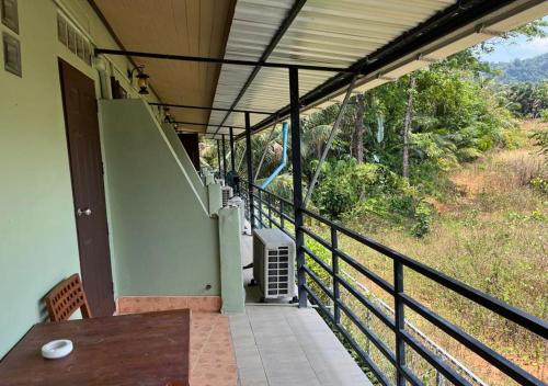 a balcony of a house with a table and a view at Srichada Hotel Khaolak - SHA Extra Plus in Khao Lak