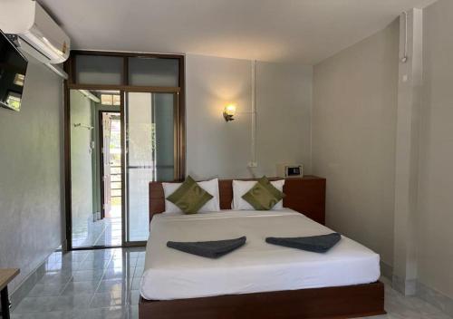 a bedroom with a large white bed with two pillows at Srichada Hotel Khaolak - SHA Extra Plus in Khao Lak