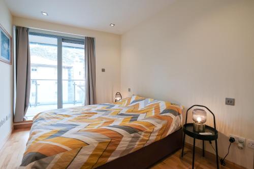 um quarto com uma cama e uma grande janela em Ocean Village 2 bedroom apartment em Gibraltar
