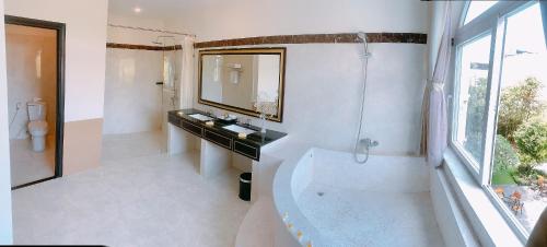 un bagno con vasca, lavandino e specchio di Boulevard Phú Quốc PQ - by BAY LUXURY a Phu Quoc