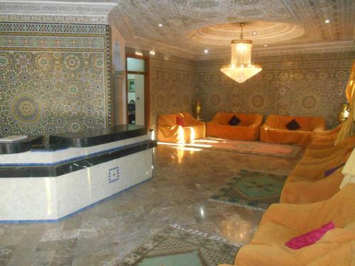 a living room with orange furniture and a couch at Hotel Babel in Nador