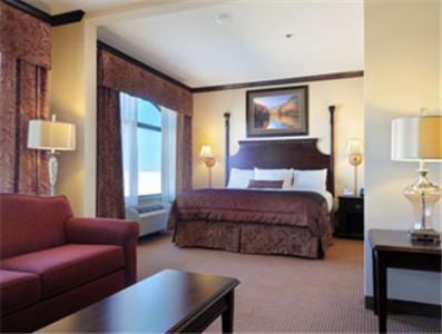 a hotel room with a bed and a couch at Big Country Hotel & Suites in Abilene
