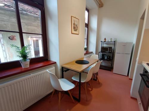 a room with a table and chairs and a window at PIF Apartments Hirscher in Braşov