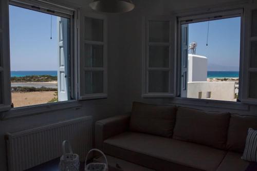 a living room with two windows and a couch at Glifada Sea View penthouse in Kastraki Naxou