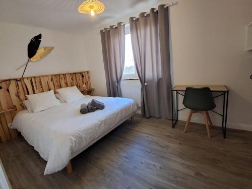 une chambre avec un lit, un bureau et une fenêtre dans l'établissement Grand gîte des pins, à Chaumousey