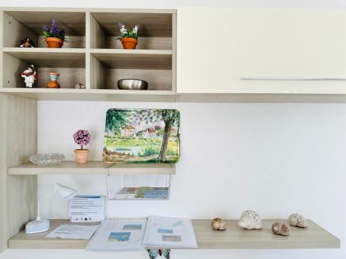 a desk with a painting on a shelf at Piccola Luna in Menaggio