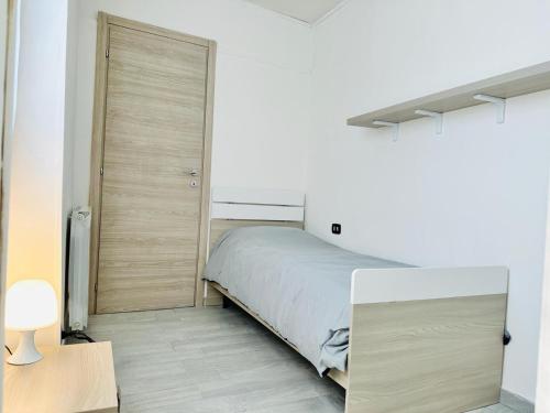 a bedroom with a bed and a wooden door at Piccola Luna in Menaggio