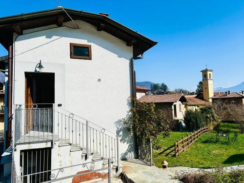 a small white building with a balcony and a door at Piccola Luna in Menaggio