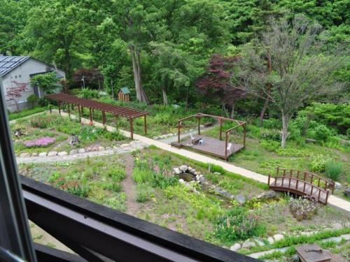 小樽市にあるRyobou Hanaemi Hotelのベンチと公園のある庭園の景色を望めます。