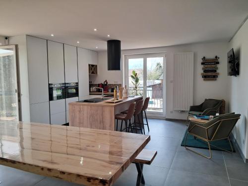 une cuisine avec une table en bois et un îlot de cuisine dans l'établissement Grand gîte des pins, à Chaumousey