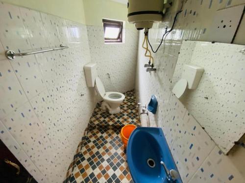 uma casa de banho com um WC e um lavatório azul em BOB Lesiure em Ooty