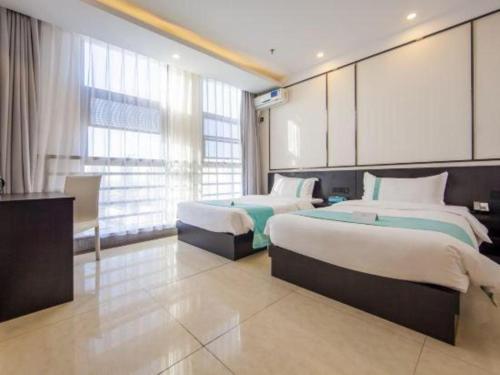 um quarto de hotel com duas camas e uma grande janela em Xana Hotelle Tianjin Jingang Road Huaxi Branch em Jinnanqu
