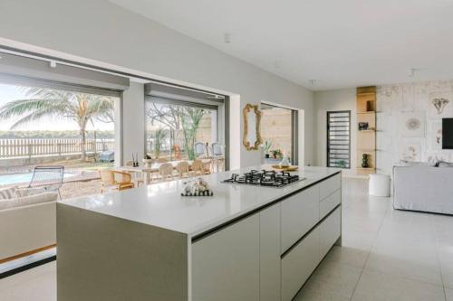 a white kitchen with a stove top island in a room at Tamarin Sunset Beach V in Tamarin