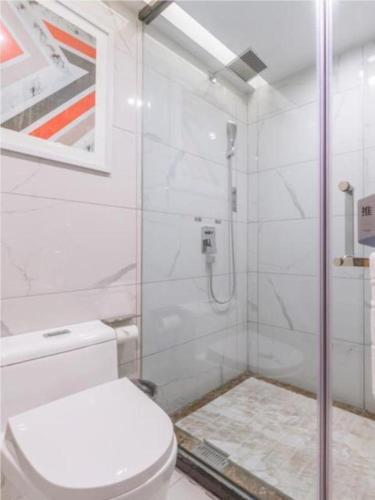 uma casa de banho com um WC e uma cabina de duche em vidro. em Borrman Hotel Kunming Dianchi South Asia Fengqingyuan em Kunming