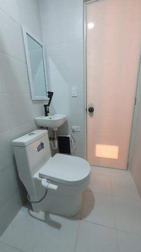DRA Guesthouse في Romblon: حمام ابيض مع مرحاض ومغسلة