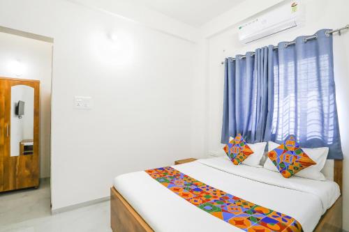 1 dormitorio con 1 cama con cortina azul en FabHotel Blue Ocean MNJ Resort en Nashik