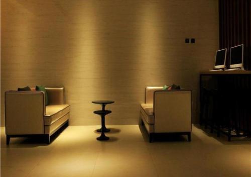 a room with two chairs and a table and a stool at City Comfort Inn Hefei Wulimiao Feihe Road in Hefei