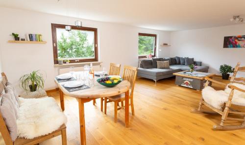 sala de estar con mesa, sillas y sofá en Bei den Hartmanns en Rieden am Forggensee