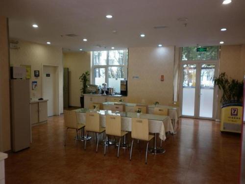 uma cozinha com mesa e cadeiras num quarto em 7 Days Inn Tianjin Development Zone Fifth Street Convention Center em Binhai