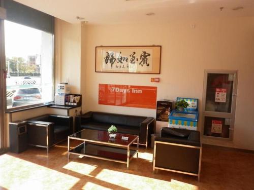 uma sala de estar com um sofá e uma mesa em 7 Days Inn Tianjin Development Zone Fifth Street Convention Center em Binhai