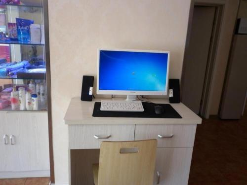 a desk with a computer monitor and a keyboard and mouse at 7 Days Inn Tianjin Development Zone Fifth Street Convention Center in Binhai