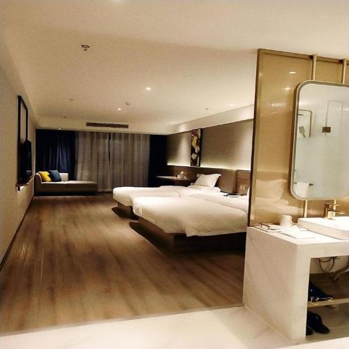 1 dormitorio con 1 cama grande y espejo en 7 Days Premium Hotel Chongqing Jiangbei International Airport Terminal 3 en Shiping