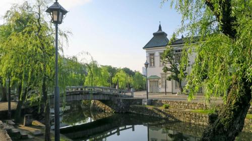 a bridge over a river in front of a building at Toyoko Inn Kurashiki-eki Minami-guchi in Kurashiki